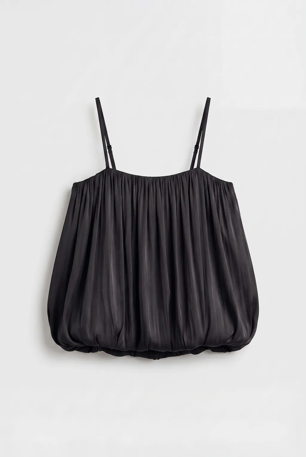 Black gathered camisole with thin straps and a bubble hem, on a white background