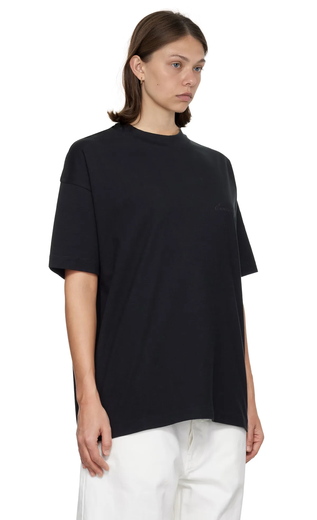 Model in a black oversized tee and white wide-leg trousers, front view on a white studio background