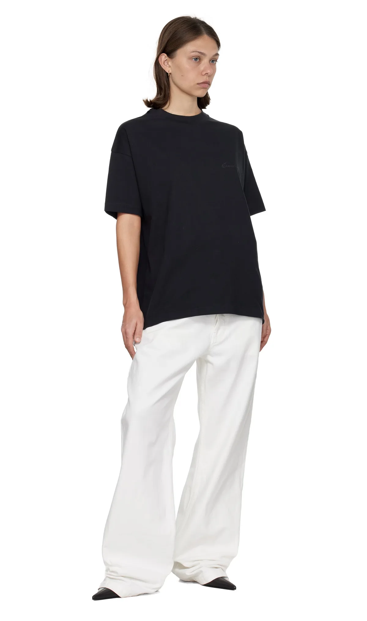 Three-quarter back view of the model in the black tee and white wide-leg trousers